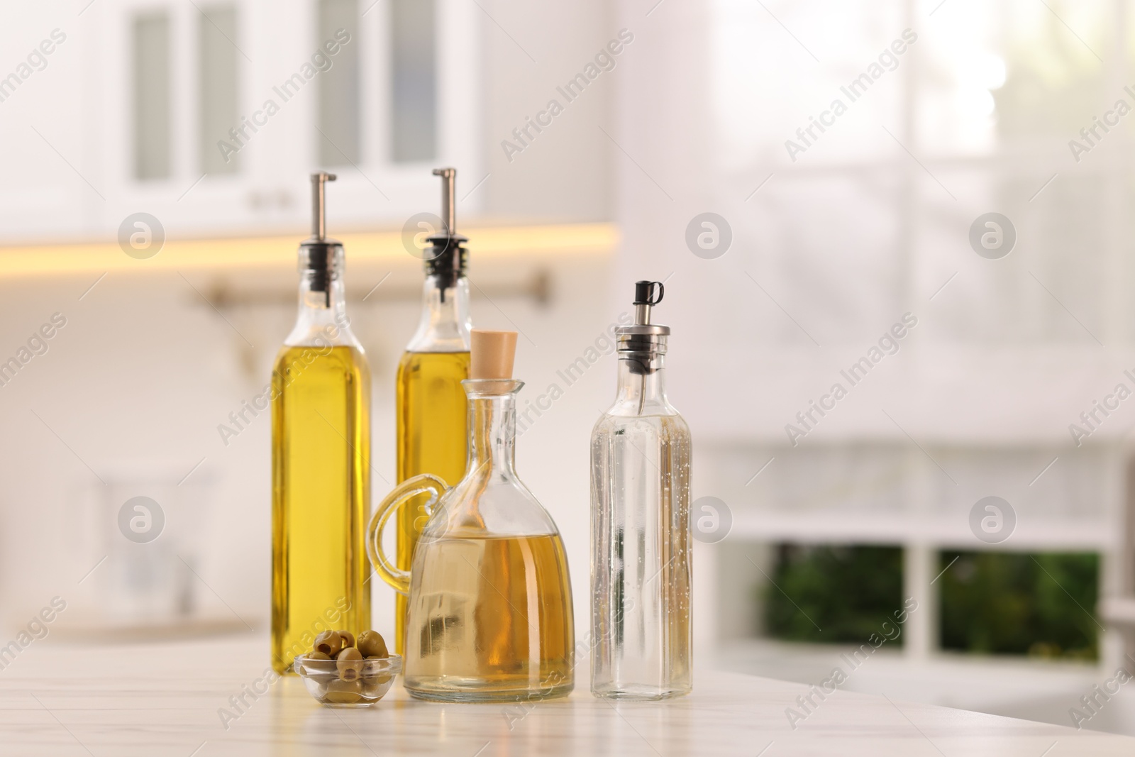 Photo of Salad dressings and olives on table in kitchen. Space for text