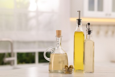 Photo of Salad dressings and olives on table in kitchen. Space for text