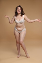 Photo of Beautiful woman in underwear on dark beige background. Cellulite problem