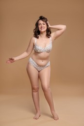 Photo of Beautiful woman in underwear on dark beige background. Cellulite problem