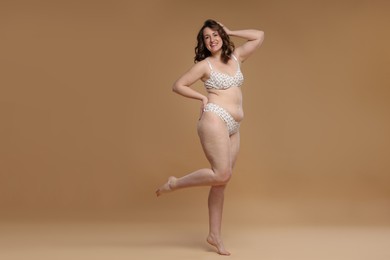 Photo of Beautiful woman in underwear on dark beige background. Cellulite problem