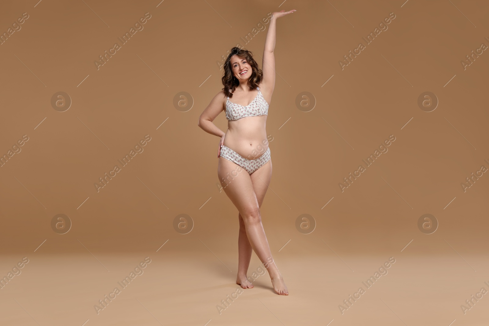 Photo of Beautiful woman in underwear on dark beige background. Cellulite problem