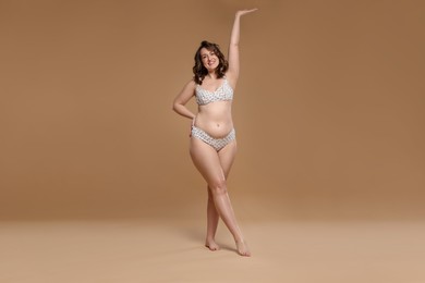 Photo of Beautiful woman in underwear on dark beige background. Cellulite problem