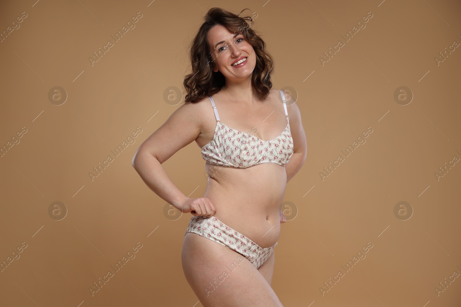 Photo of Beautiful woman in underwear on dark beige background. Cellulite problem