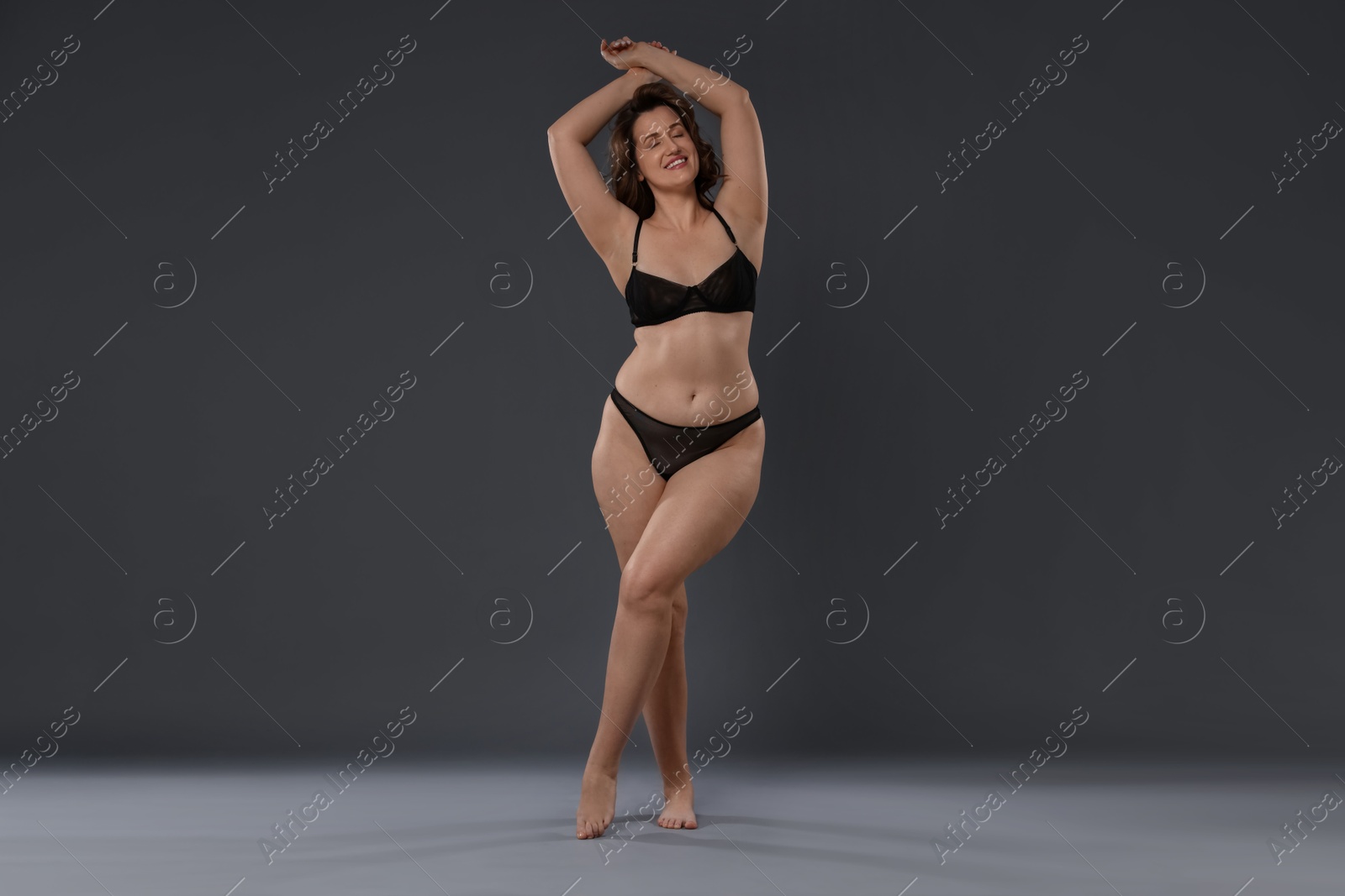 Photo of Beautiful woman in underwear on dark grey background. Cellulite problem