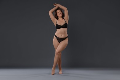 Photo of Beautiful woman in underwear on dark grey background. Cellulite problem