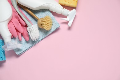 Photo of Detergents and supplies on pink background, flat lay. Space for text