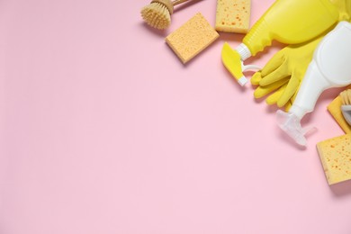 Photo of Detergents and supplies on pink background, flat lay. Space for text