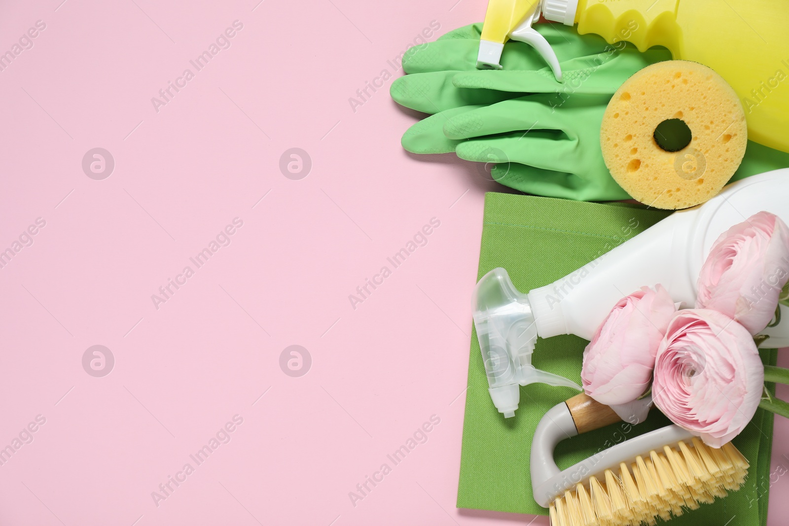 Photo of Spring cleaning. Detergents, supplies and flowers on pink background, flat lay. Space for text