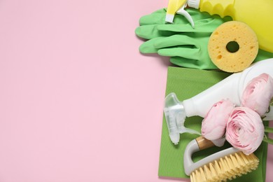 Photo of Spring cleaning. Detergents, supplies and flowers on pink background, flat lay. Space for text