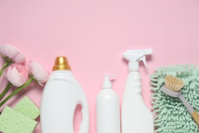 Photo of Spring cleaning. Detergents, supplies and flowers on pink background, flat lay. Space for text