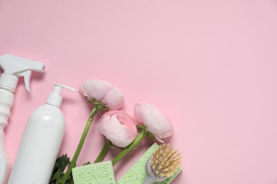 Photo of Spring cleaning. Detergents, supplies and flowers on pink background, flat lay. Space for text