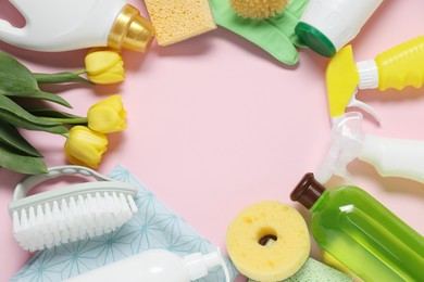 Photo of Spring cleaning. Detergents, supplies and tulips on pink background, flat lay. Space for text