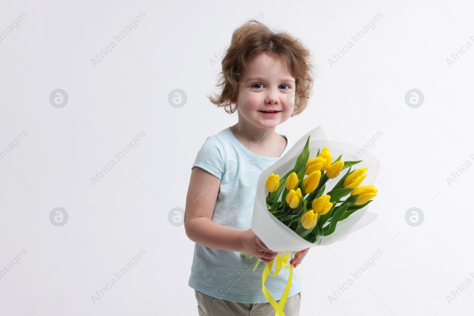 Photo of Cute little boy with bouquet of tulips on white background