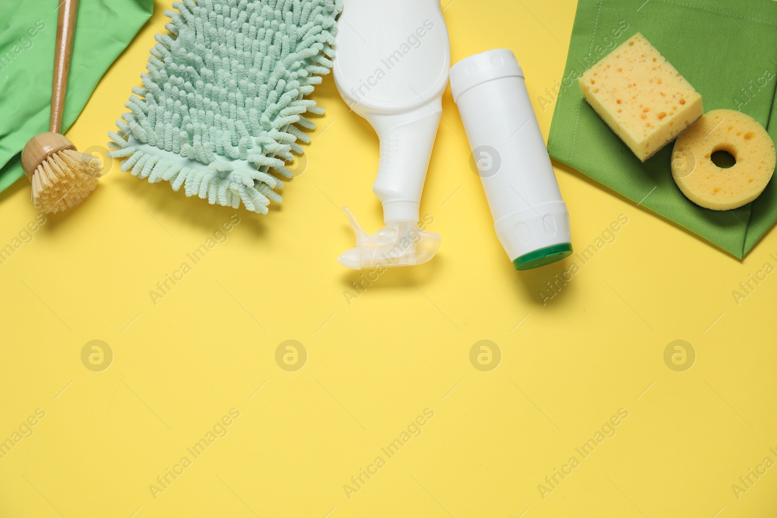 Photo of Detergents and supplies on yellow background, flat lay. Space for text