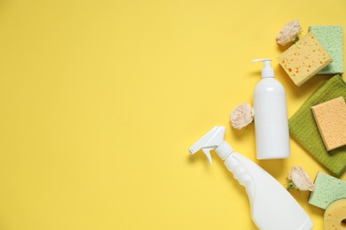 Photo of Spring cleaning. Detergents, supplies and flowers on yellow background, flat lay. Space for text