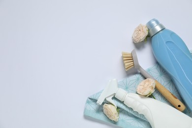 Photo of Spring cleaning. Detergents, supplies and flowers on white background, flat lay. Space for text