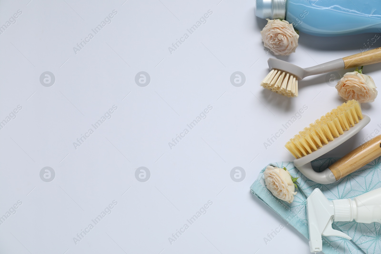 Photo of Spring cleaning. Detergents, supplies and flowers on white background, flat lay. Space for text