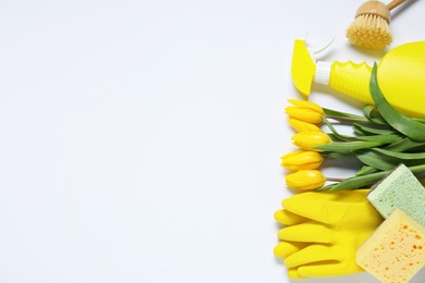 Photo of Spring cleaning. Detergent, supplies and tulips on white background, flat lay. Space for text