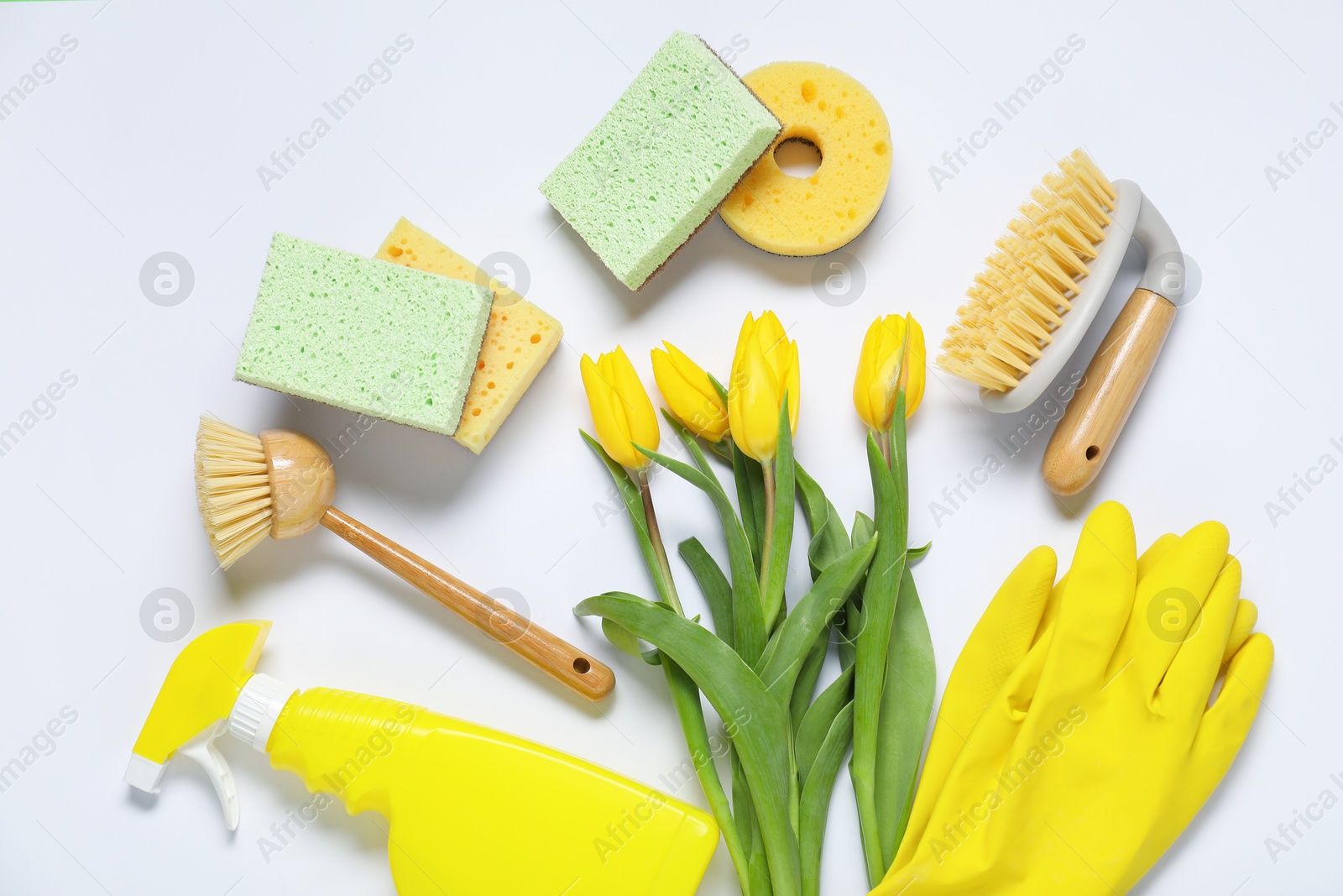 Photo of Spring cleaning. Detergent, supplies and tulips on white background, flat lay