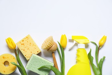 Photo of Spring cleaning. Detergent, supplies and tulips on white background, flat lay. Space for text