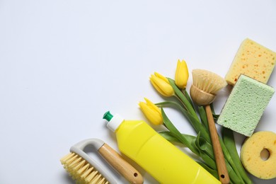 Photo of Spring cleaning. Detergent, supplies and tulips on white background, flat lay. Space for text