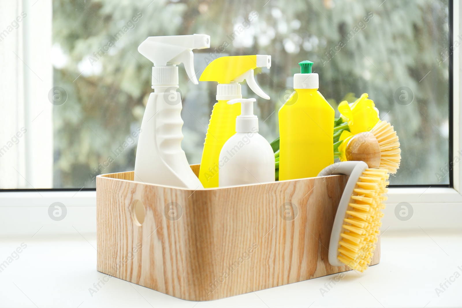 Photo of Spring cleaning. Detergents, supplies and flowers on windowsill indoors