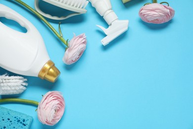 Photo of Spring cleaning. Detergents, supplies and flowers on light blue background, flat lay. Space for text