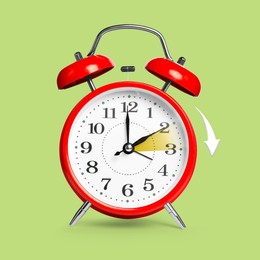 Image of Daylight saving time. Red alarm clock on light green background. Highlighted area and arrow showing time change by one hour forward