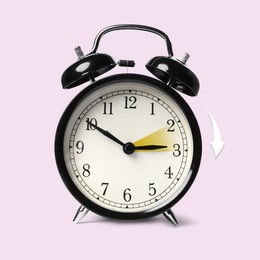 Image of Daylight saving time. Black alarm clock on light pink background. Highlighted area and arrow showing time change by one hour forward