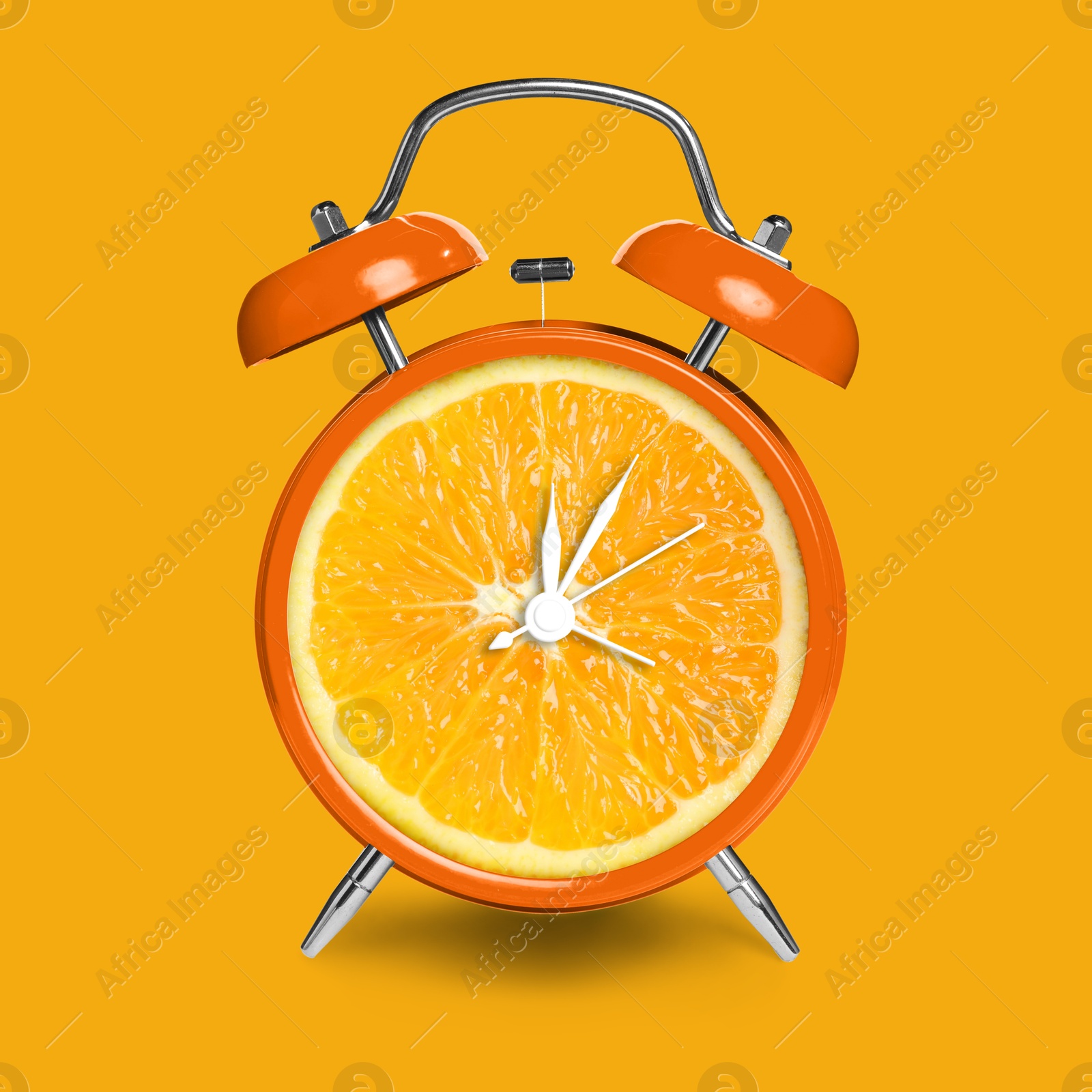 Image of Alarm clock with sliced orange instead of dial on orange background