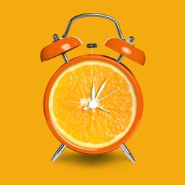 Image of Alarm clock with sliced orange instead of dial on orange background