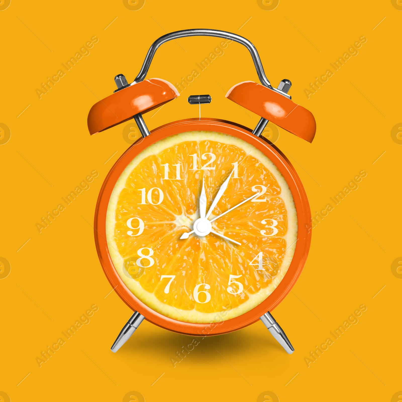 Image of Alarm clock with sliced orange instead of dial on orange background