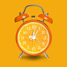 Image of Alarm clock with sliced orange instead of dial on orange background