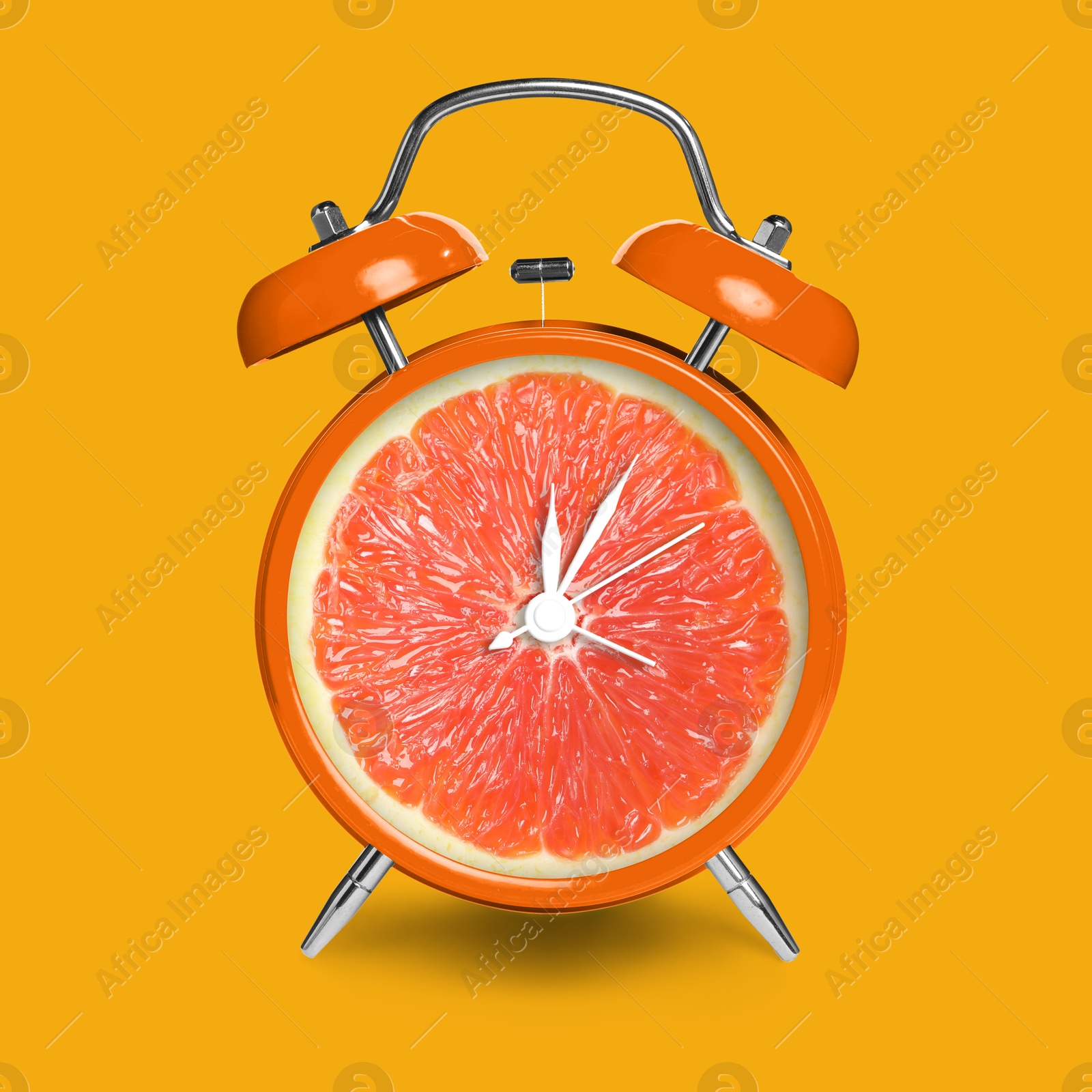 Image of Alarm clock with sliced orange instead of dial on orange background