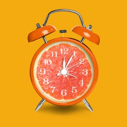 Image of Alarm clock with sliced orange instead of dial on orange background