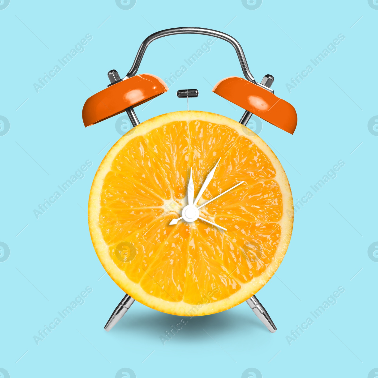 Image of Alarm clock with sliced orange instead of dial on light blue background