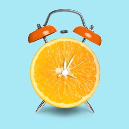 Image of Alarm clock with sliced orange instead of dial on light blue background