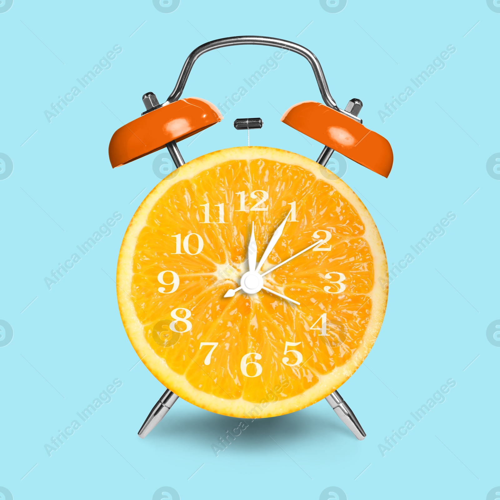 Image of Alarm clock with sliced orange instead of dial on light blue background