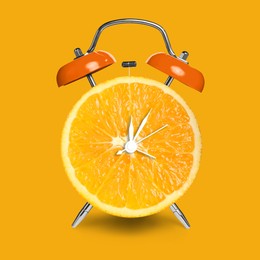 Image of Alarm clock with sliced orange instead of dial on orange background