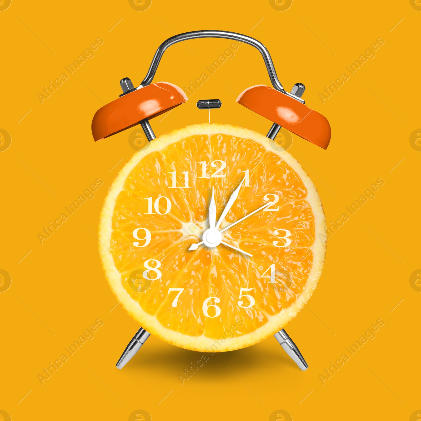 Image of Alarm clock with sliced orange instead of dial on orange background