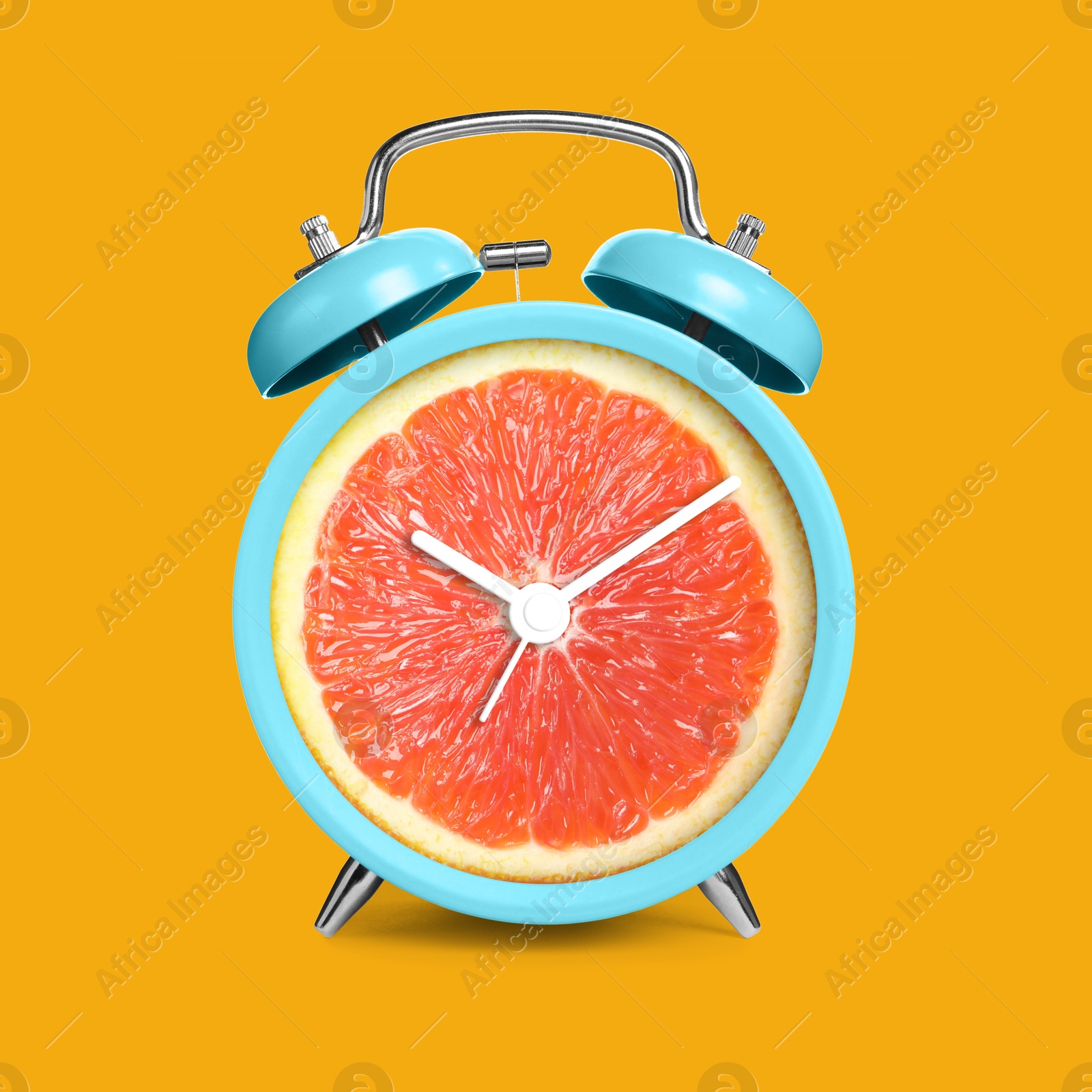 Image of Alarm clock with sliced orange instead of dial on orange background