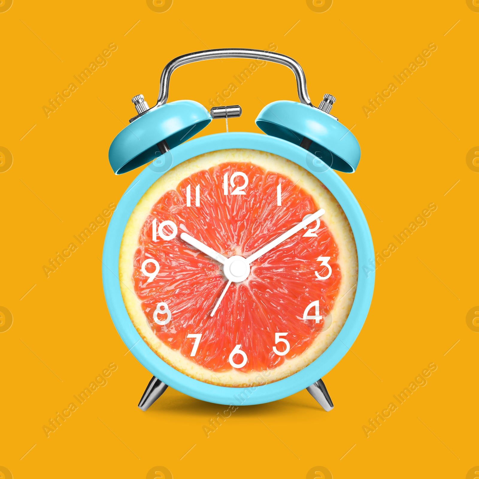 Image of Alarm clock with sliced orange instead of dial on orange background