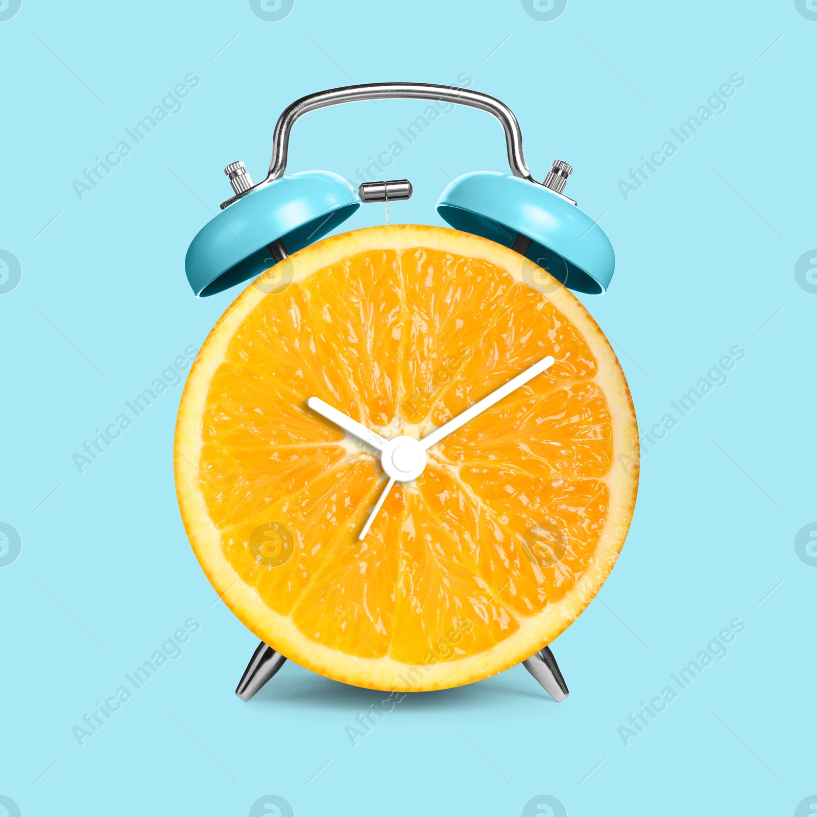 Image of Alarm clock with sliced orange instead of dial on light blue background