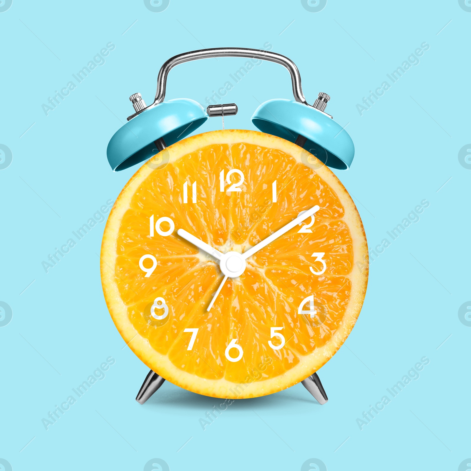 Image of Alarm clock with sliced orange instead of dial on light blue background