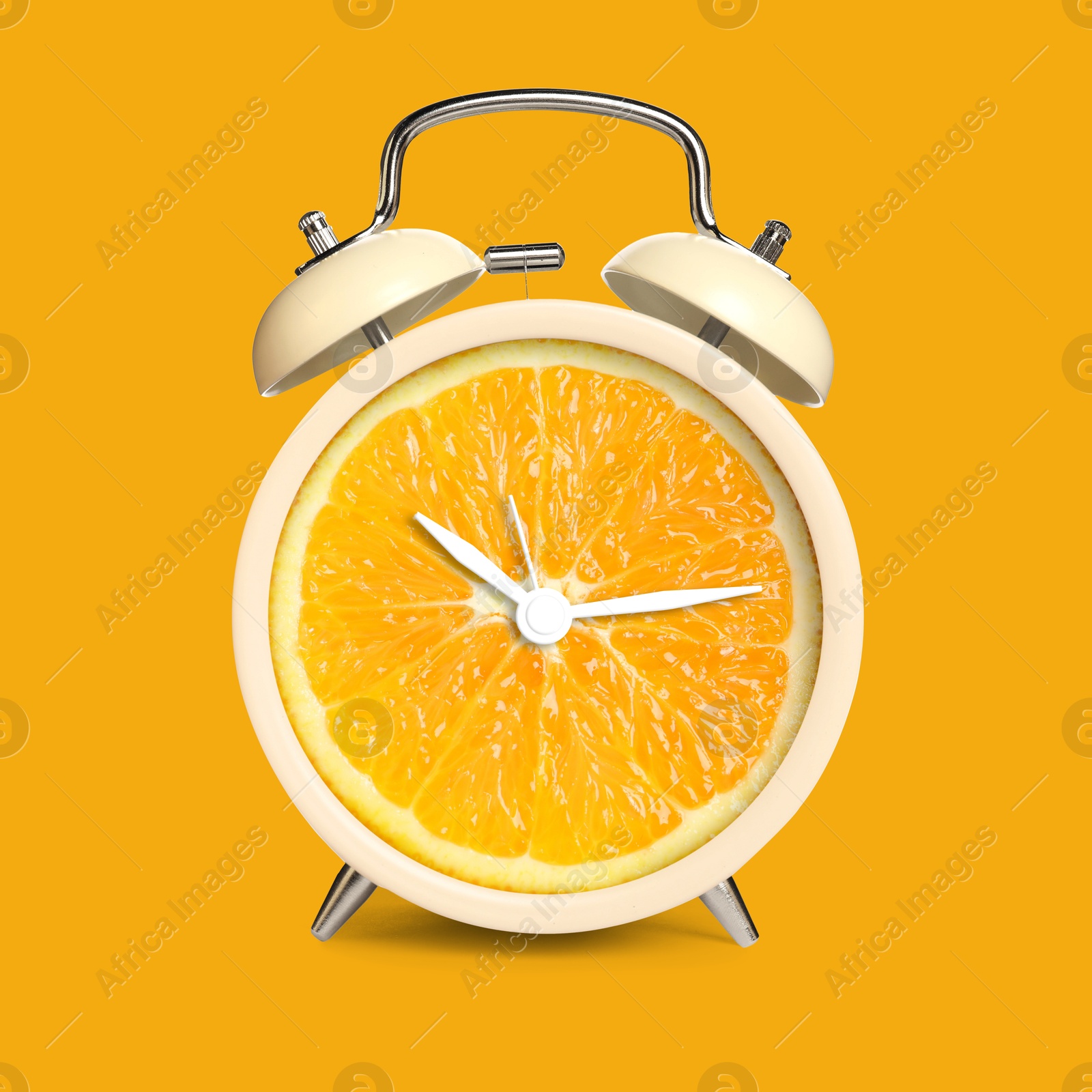 Image of Alarm clock with sliced orange instead of dial on orange background