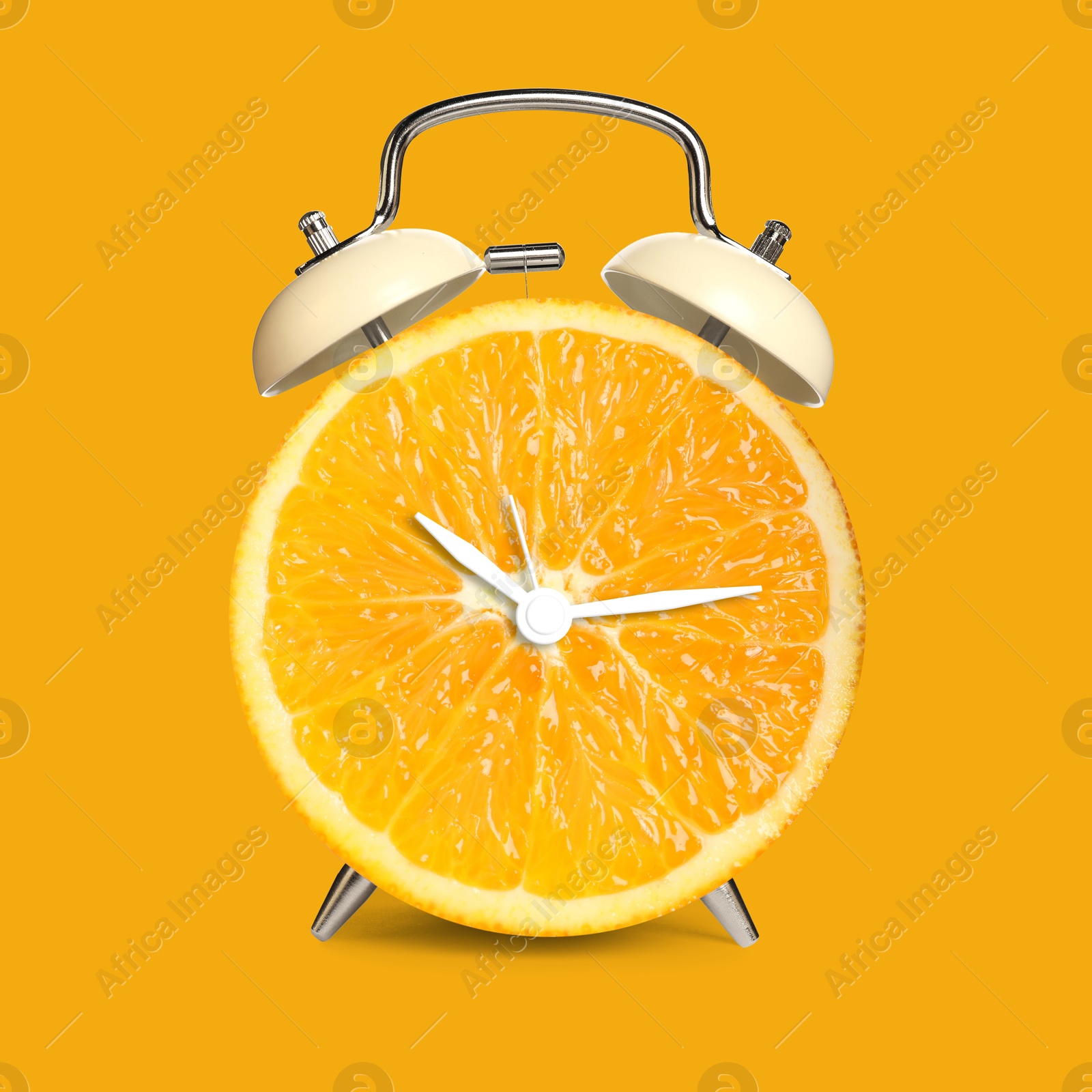 Image of Alarm clock with sliced orange instead of dial on orange background