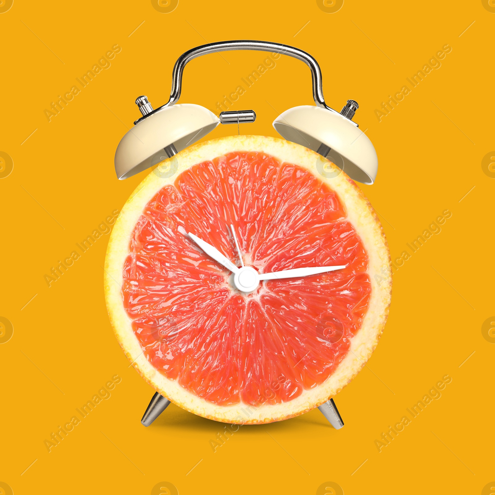 Image of Alarm clock with sliced orange instead of dial on orange background