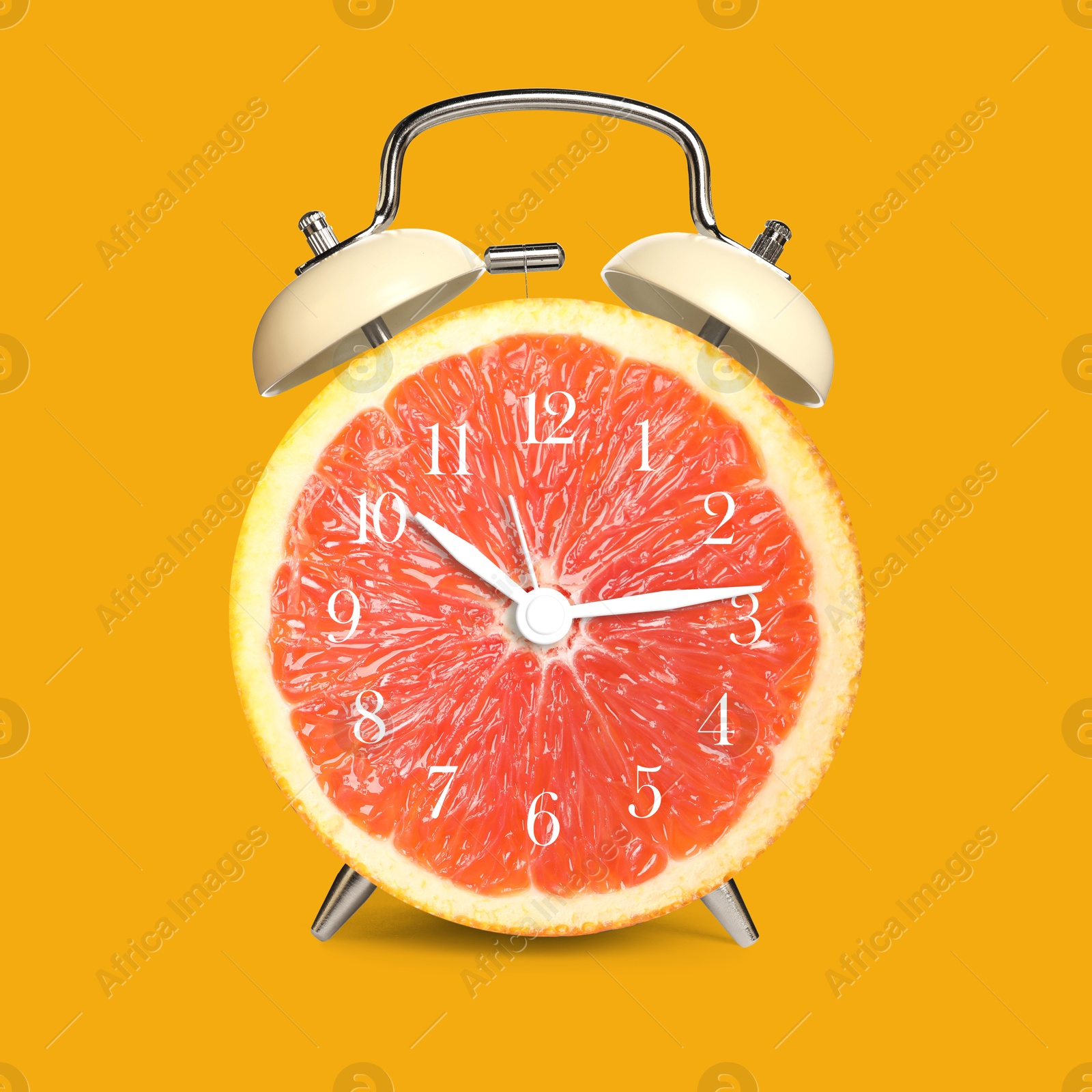 Image of Alarm clock with sliced orange instead of dial on orange background