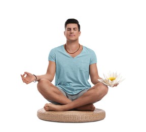 Man meditating with beautiful lotus flower in his hand on white background. Padmasana (yoga lotus position)